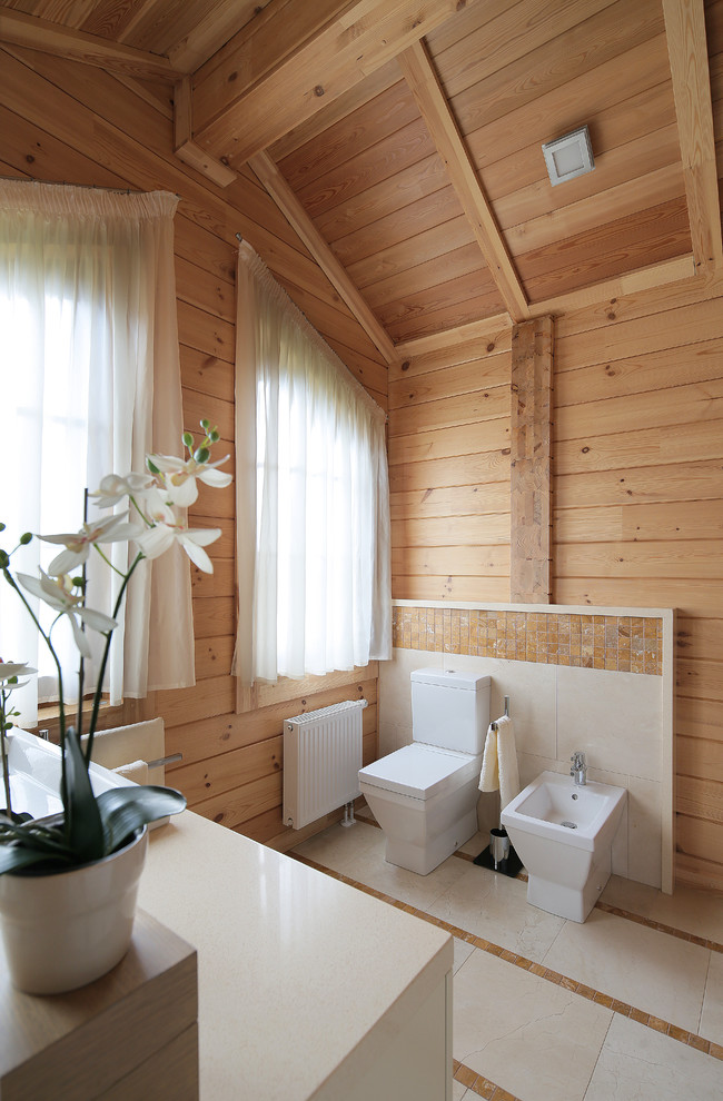 Cette image montre un grand WC et toilettes rustique avec des portes de placard blanches, un carrelage marron, mosaïque, un mur beige et un sol beige.
