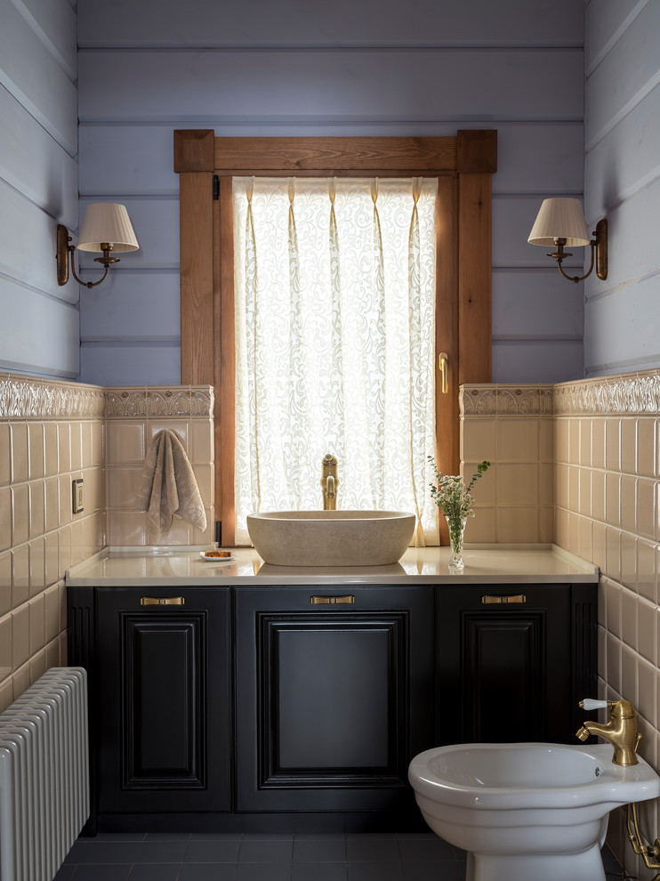 Inspiration för ett lantligt beige beige toalett, med beige kakel, keramikplattor, blå väggar, cementgolv, ett fristående handfat, marmorbänkskiva, luckor med upphöjd panel, svarta skåp, en bidé och grått golv