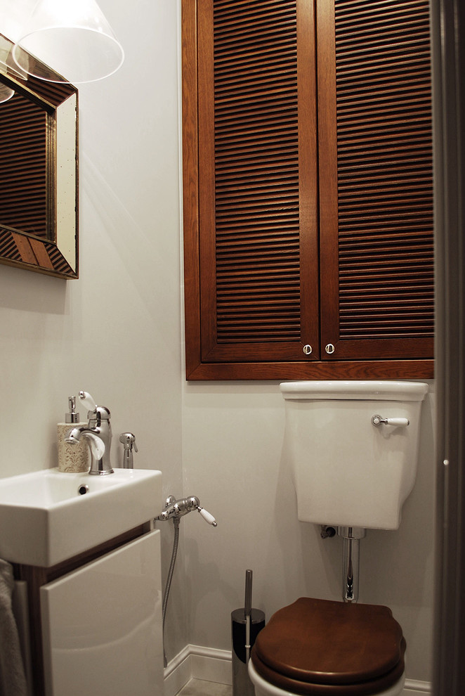 Photo of a small classic cloakroom in Moscow with louvered cabinets, dark wood cabinets, a two-piece toilet, grey walls, ceramic flooring, a console sink and grey floors.