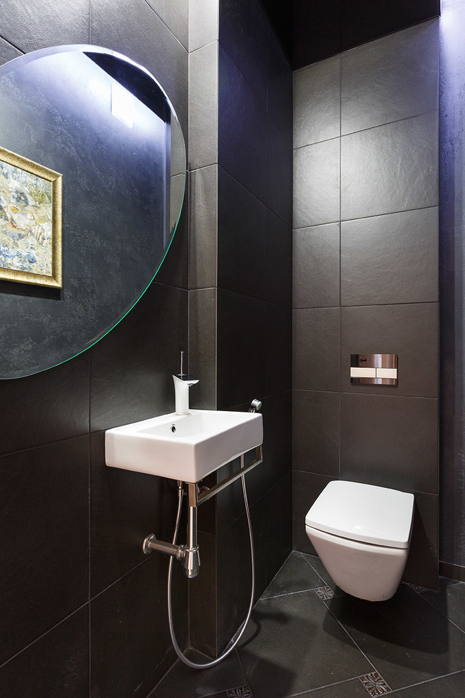 Foto de aseo contemporáneo con sanitario de pared, baldosas y/o azulejos negros y lavabo suspendido