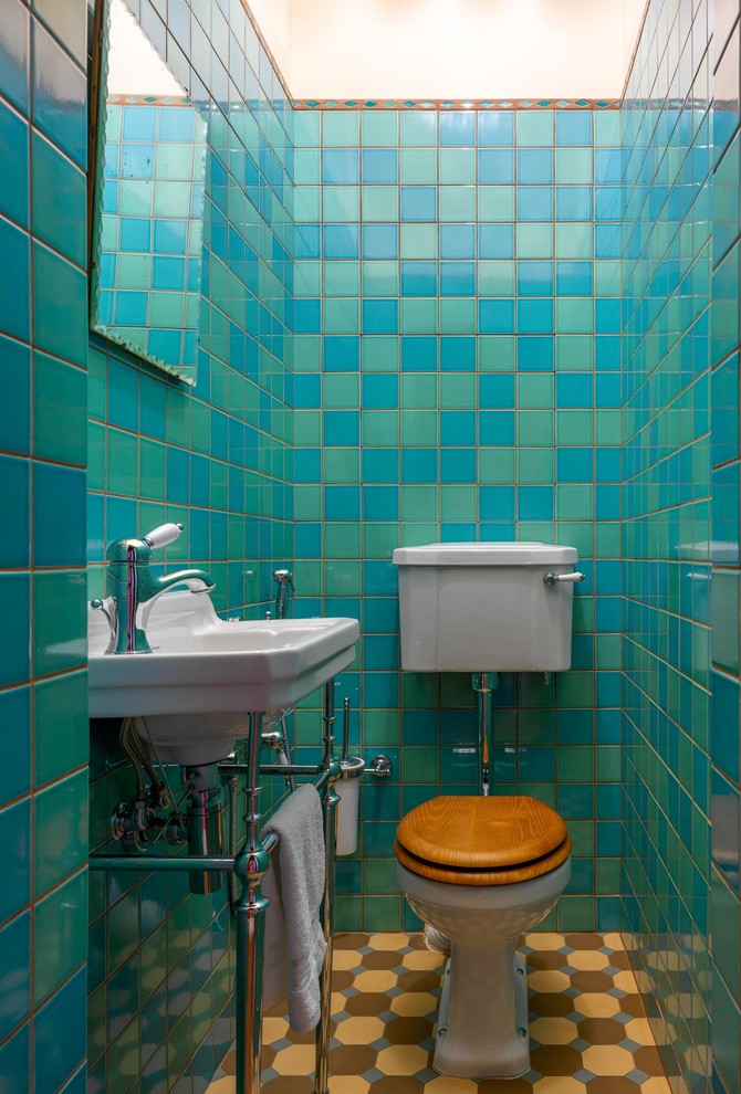 Kleine Retro Gästetoilette mit Wandtoilette mit Spülkasten, Keramikfliesen, bunten Wänden, Keramikboden, Waschtischkonsole und braunem Boden in Moskau
