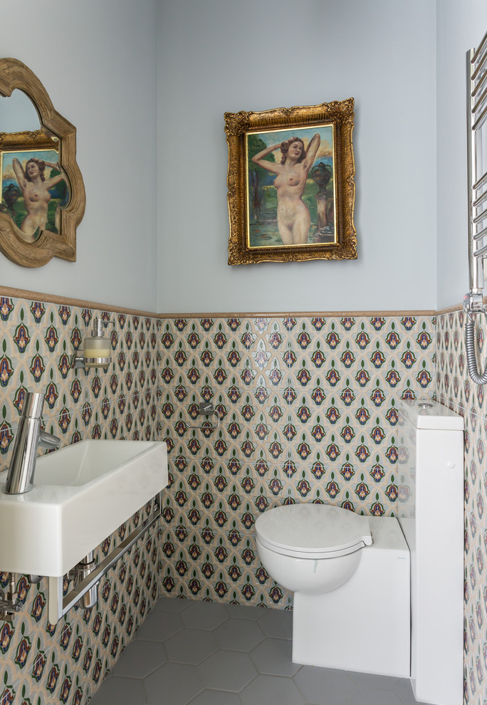 Foto på ett litet vintage vit toalett, med flerfärgad kakel, ett väggmonterat handfat, grått golv, en toalettstol med hel cisternkåpa, keramikplattor, flerfärgade väggar, klinkergolv i porslin, öppna hyllor, vita skåp och granitbänkskiva