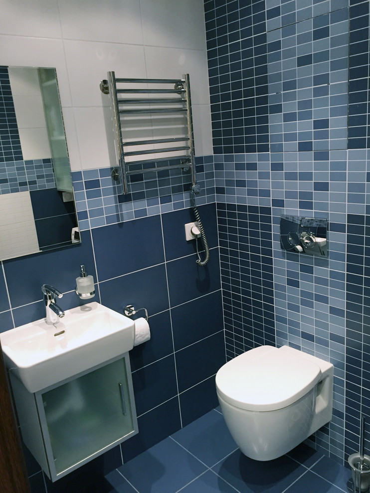 На фото: туалет среднего размера в современном стиле с стеклянными фасадами, инсталляцией, синей плиткой, керамической плиткой, разноцветными стенами, полом из керамогранита, подвесной раковиной и синим полом с