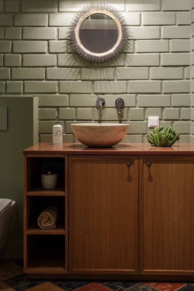 Ispirazione per un bagno di servizio design con ante in legno scuro, pareti verdi, lavabo a bacinella, top marrone, ante con riquadro incassato, piastrelle verdi, top in legno e pavimento verde