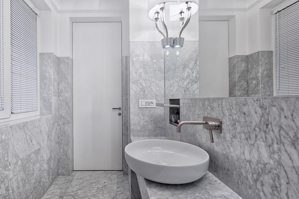 Пример оригинального дизайна: туалет в современном стиле с серой плиткой, белыми стенами, настольной раковиной и серым полом