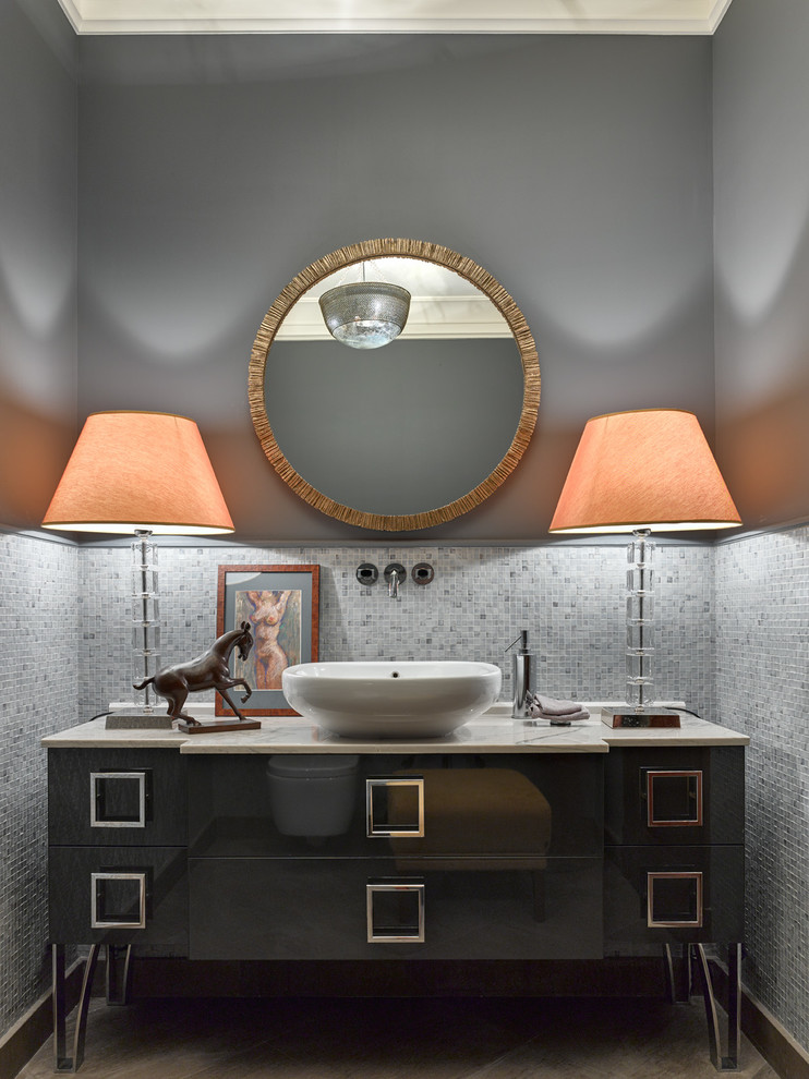 Aménagement d'un WC et toilettes classique avec des portes de placard grises, un carrelage gris, mosaïque, un mur gris, une vasque, un placard à porte plane et un plan de toilette en marbre.