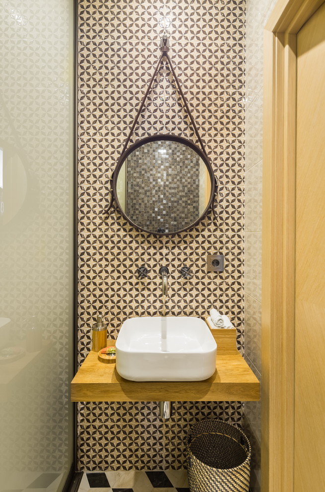 モスクワにあるコンテンポラリースタイルのおしゃれなトイレ・洗面所 (ベージュのタイル、ベッセル式洗面器、木製洗面台、ブラウンの洗面カウンター) の写真