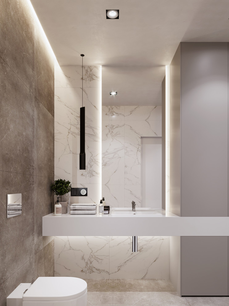 Immagine di un piccolo bagno di servizio design con WC sospeso, piastrelle bianche, piastrelle di marmo, pavimento in gres porcellanato, top in superficie solida, pavimento grigio, top bianco e lavabo integrato