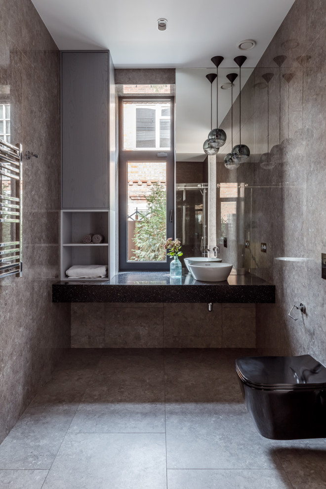 Пример оригинального дизайна: большой туалет в современном стиле с серой плиткой и серым полом