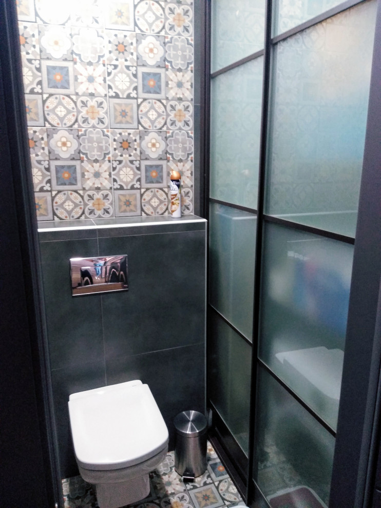 Inspiration för små moderna toaletter, med luckor med glaspanel, en vägghängd toalettstol, svart kakel, klinkergolv i porslin och ett nedsänkt handfat