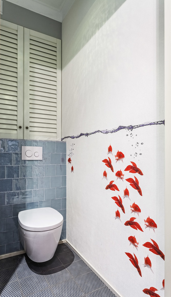 Inredning av ett modernt litet grå grått toalett, med vita skåp, en vägghängd toalettstol, klinkergolv i porslin, vita väggar, grå kakel, blå kakel, luckor med lamellpanel, perrakottakakel, ett fristående handfat, bänkskiva i akrylsten och blått golv