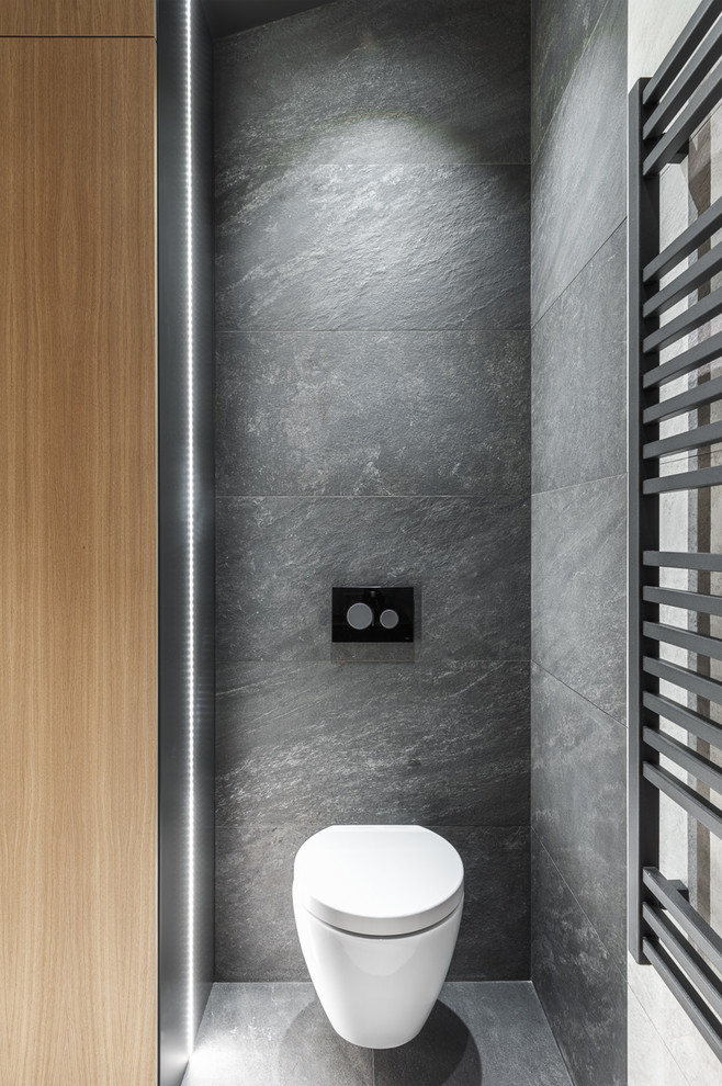 Foto di un bagno di servizio design con WC sospeso, piastrelle grigie e pavimento grigio