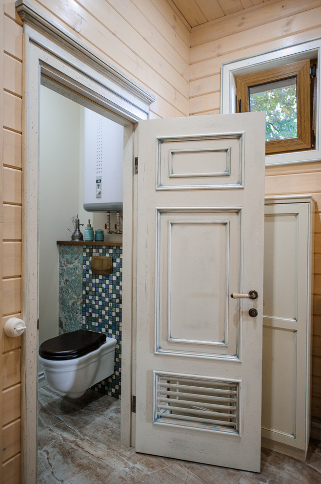 ノボシビルスクにある小さなシャビーシック調のおしゃれなトイレ・洗面所 (壁掛け式トイレ、ベージュの壁、磁器タイルの床) の写真