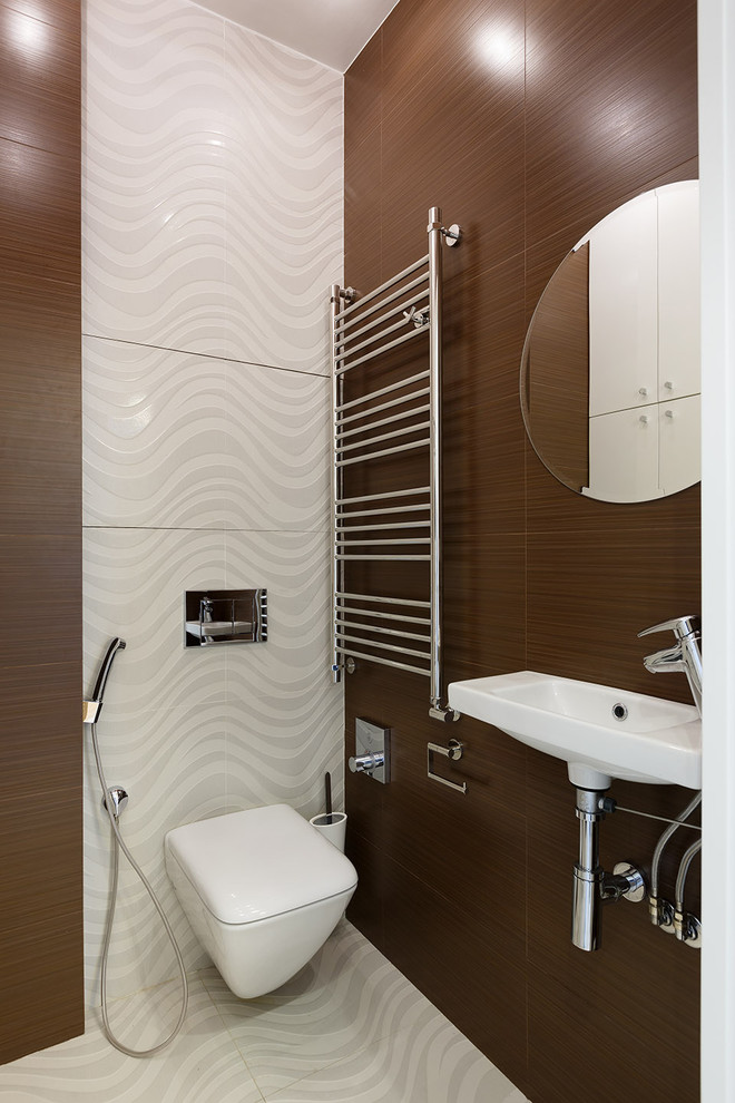 他の地域にあるコンテンポラリースタイルのおしゃれなトイレ・洗面所 (壁掛け式トイレ、白いタイル、茶色いタイル、壁付け型シンク) の写真