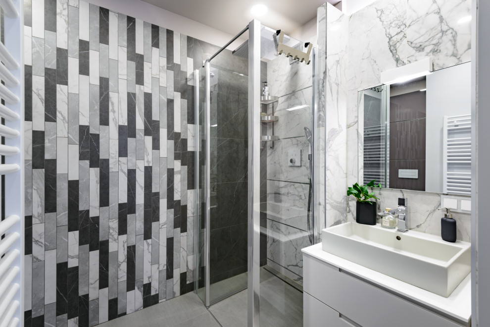 Idée de décoration pour une petite salle de bain design avec un carrelage noir et blanc, des carreaux de porcelaine, un sol en carrelage de porcelaine, une vasque, un plan de toilette en surface solide, un sol gris et un plan de toilette blanc.