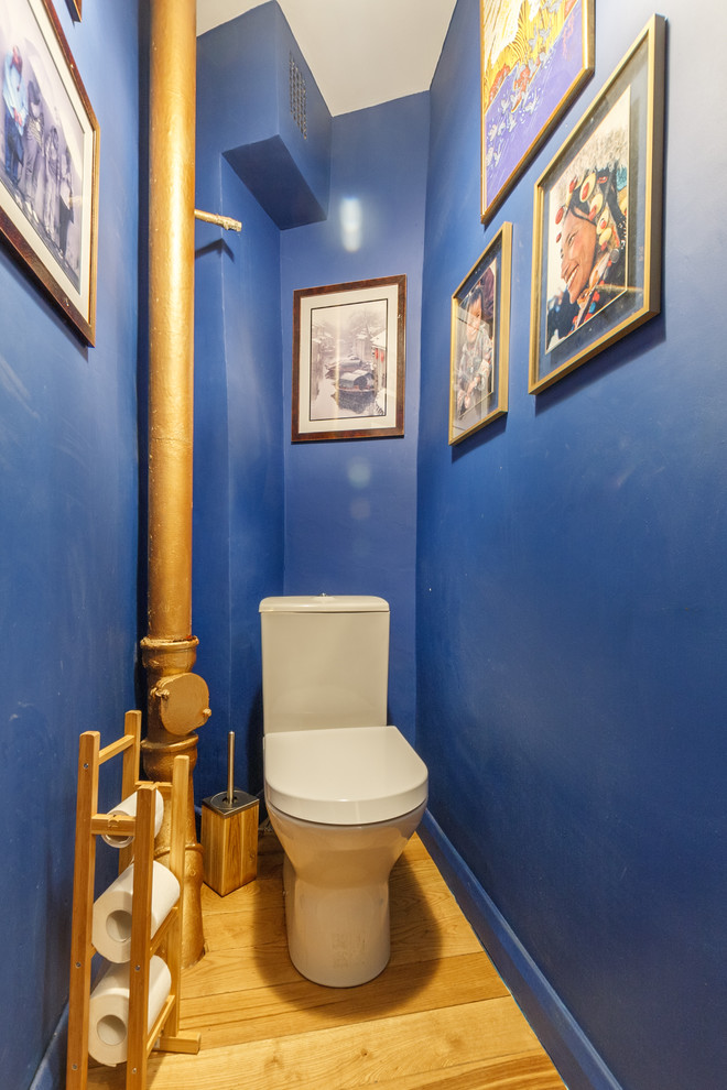 サンクトペテルブルクにあるコンテンポラリースタイルのおしゃれなトイレ・洗面所 (青い壁、無垢フローリング、一体型トイレ	) の写真