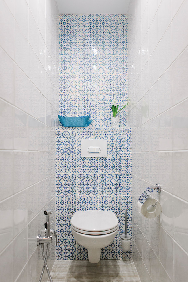 モスクワにあるコンテンポラリースタイルのおしゃれなトイレ・洗面所 (壁掛け式トイレ、青いタイル、白いタイル) の写真
