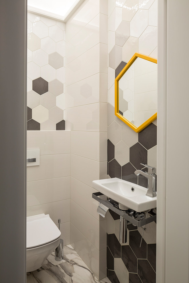 Inspiration för moderna toaletter, med en vägghängd toalettstol, vit kakel, grå kakel, svart kakel, ett väggmonterat handfat och grått golv