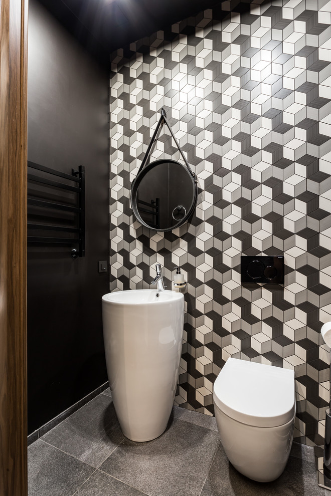 Источник вдохновения для домашнего уюта: маленький туалет в современном стиле с инсталляцией, серой плиткой, керамической плиткой, черными стенами, полом из керамогранита, монолитной раковиной и серым полом для на участке и в саду