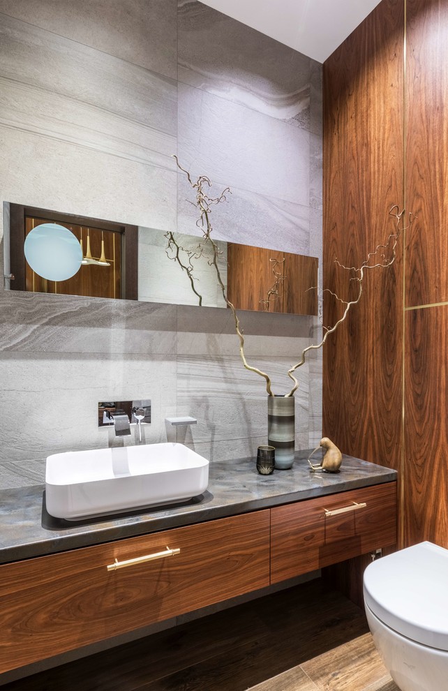 Inspiration for a contemporary gray tile and porcelain tile brown floor powder room remodel in Moscow with flat-panel cabinets, medium tone wood cabinets, a two-piece toilet and a vessel sink