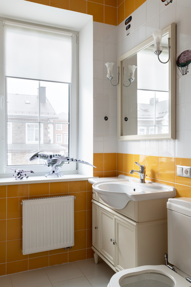 Источник вдохновения для домашнего уюта: туалет среднего размера в стиле неоклассика (современная классика) с фасадами с утопленной филенкой, бежевыми фасадами, серой плиткой, керамической плиткой, желтыми стенами, полом из керамогранита, серым полом, бежевой столешницей и раздельным унитазом