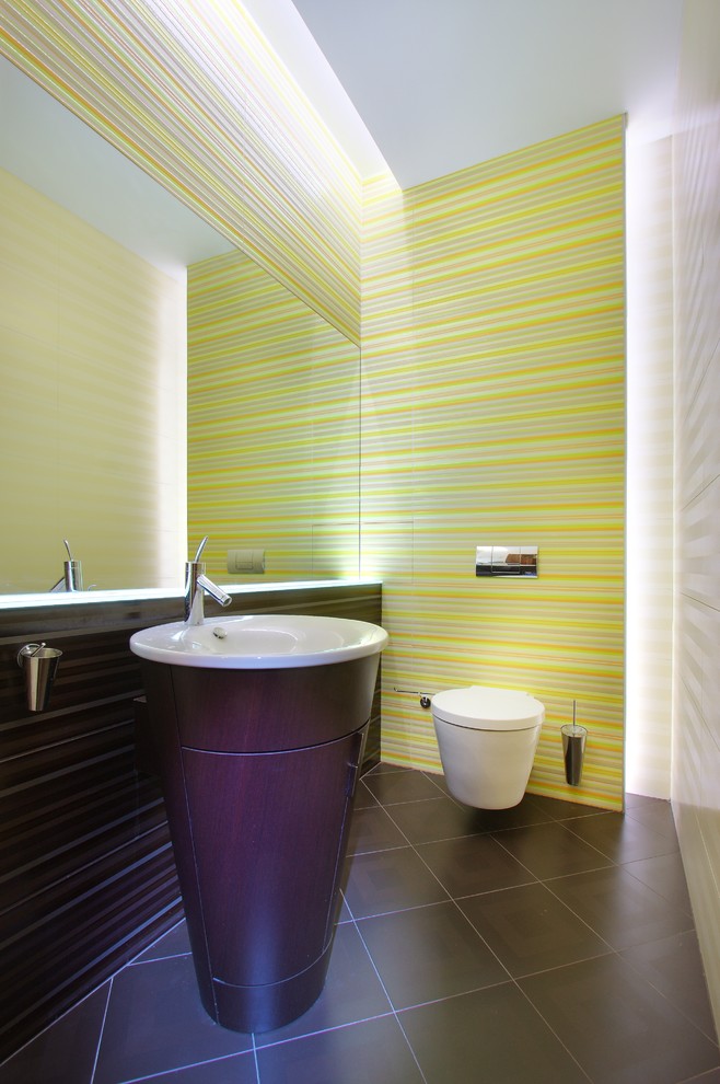Cette image montre un WC suspendu design en bois foncé de taille moyenne avec un placard en trompe-l'oeil, un carrelage multicolore, des carreaux de céramique, un mur multicolore, un sol en carrelage de céramique et un lavabo intégré.