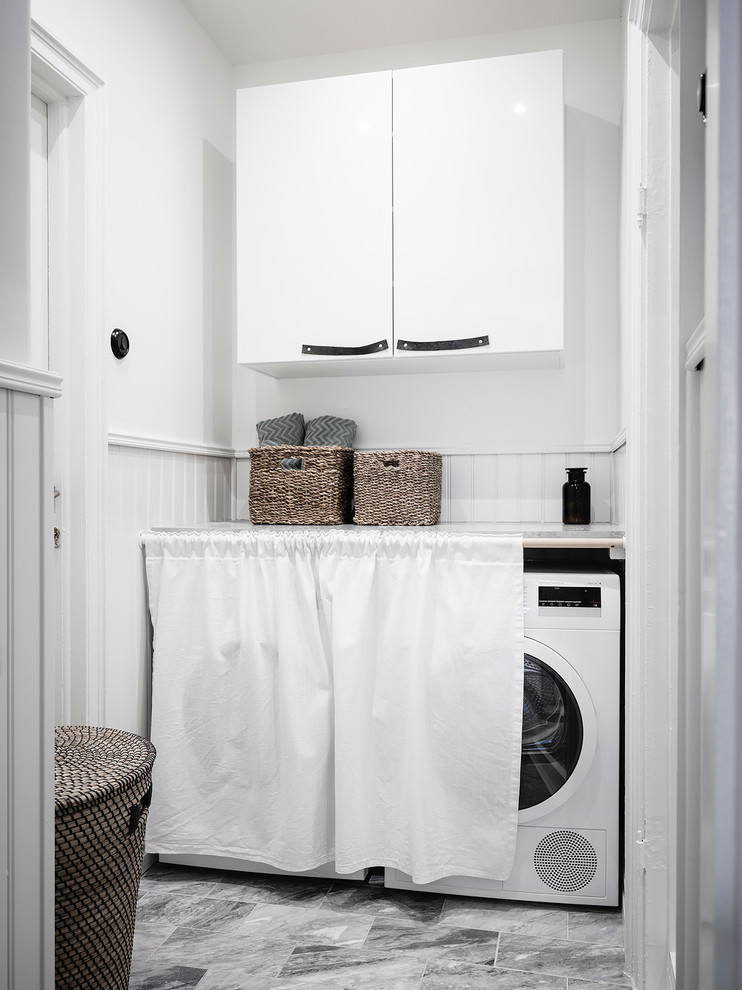 This is an example of a scandi laundry cupboard in Gothenburg with flat-panel cabinets, white cabinets and a side by side washer and dryer.