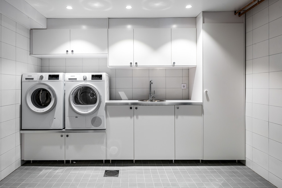 Foto de lavadero moderno de tamaño medio con armarios con paneles lisos, puertas de armario blancas y paredes blancas