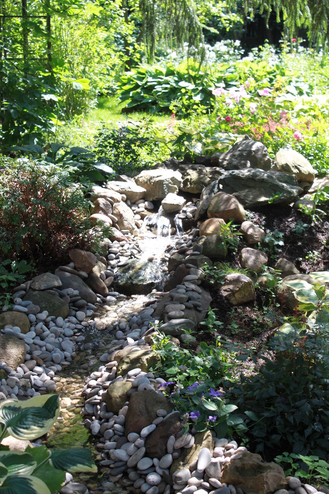 На фото: летний сад с прудом в современном стиле с полуденной тенью