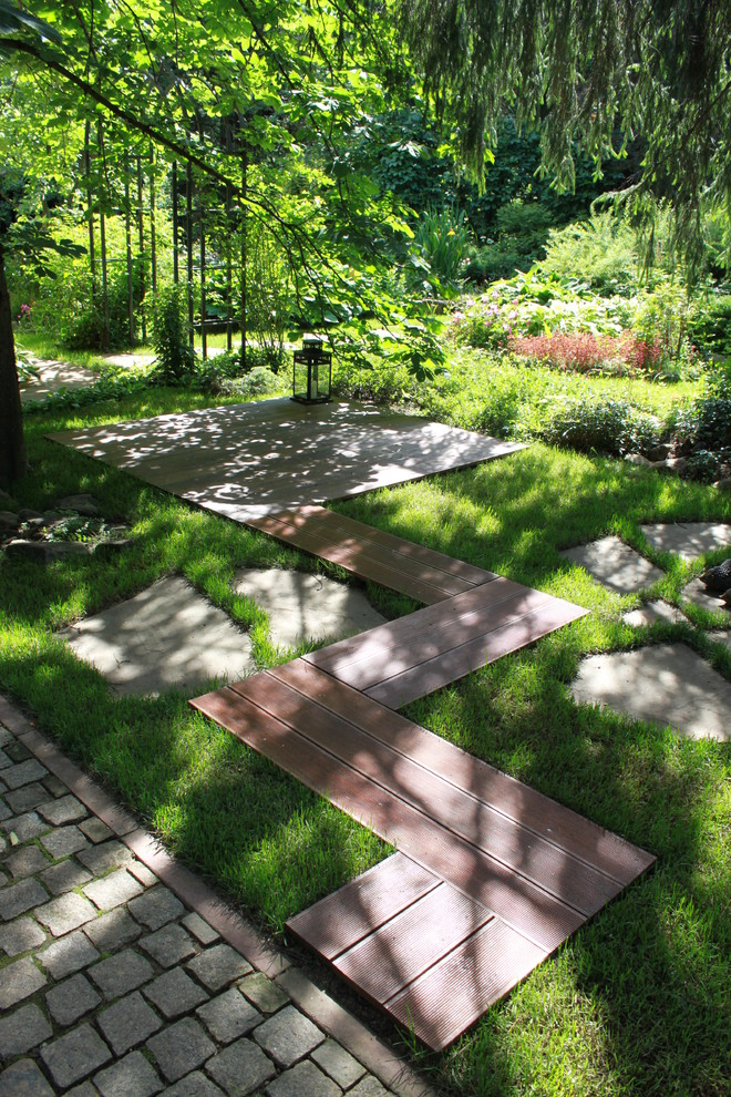 Cette photo montre un aménagement d'entrée ou allée de jardin tendance l'été avec une exposition partiellement ombragée et une terrasse en bois.
