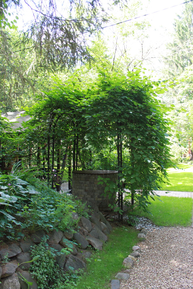 Imagen de jardín actual en verano con muro de contención, exposición parcial al sol y gravilla