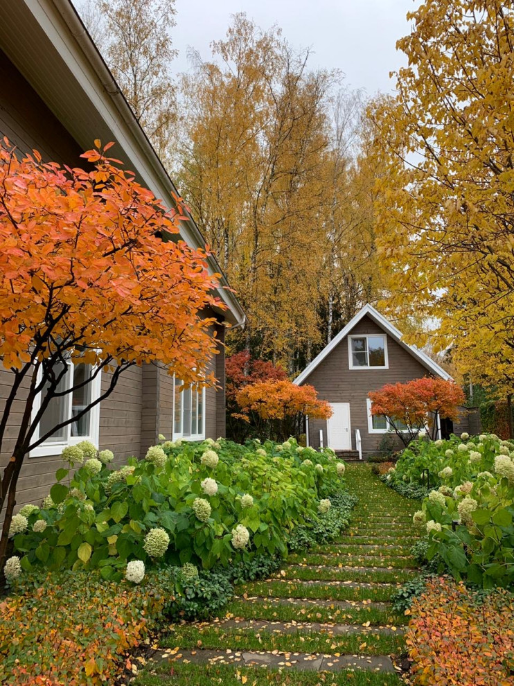 Modelo de jardín clásico de tamaño medio en otoño en patio lateral con exposición parcial al sol