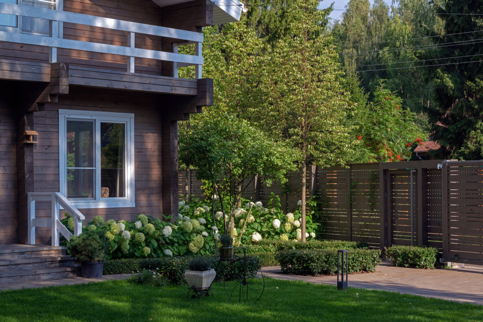 Стильный дизайн: летний участок и сад среднего размера на переднем дворе в классическом стиле с полуденной тенью, покрытием из каменной брусчатки и садовой дорожкой или калиткой - последний тренд