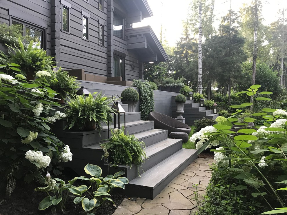 Traditional back full sun garden in Moscow with concrete paving.