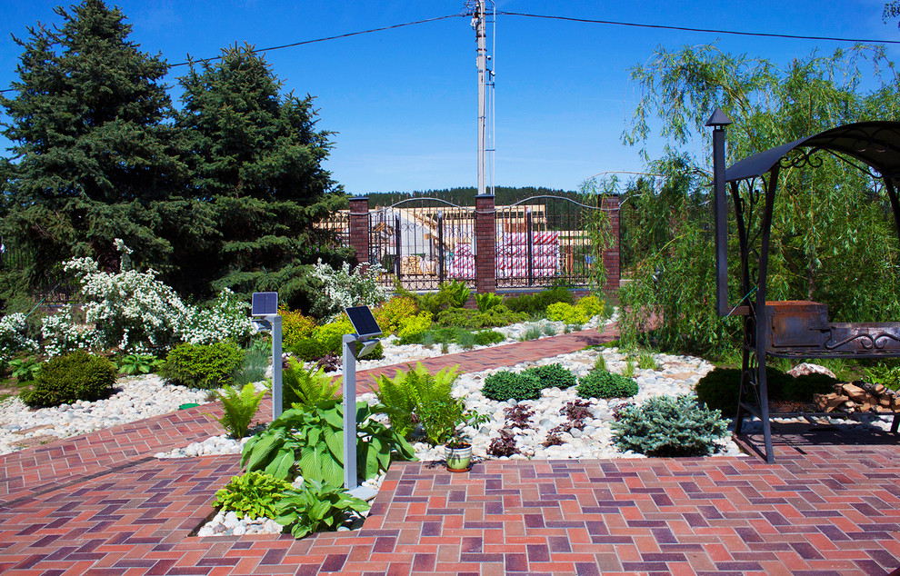 Idee per un giardino design esposto in pieno sole di medie dimensioni e in cortile in primavera con pavimentazioni in mattoni