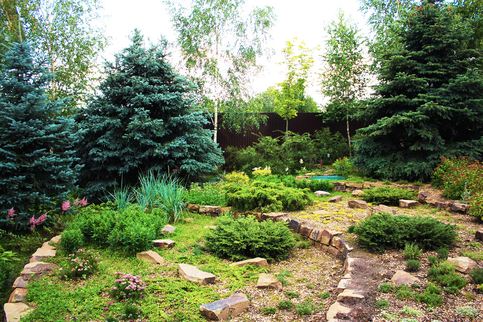Ispirazione per un giardino xeriscape minimalista esposto in pieno sole di medie dimensioni in primavera con un muro di contenimento, un pendio, una collina o una riva e pavimentazioni in pietra naturale