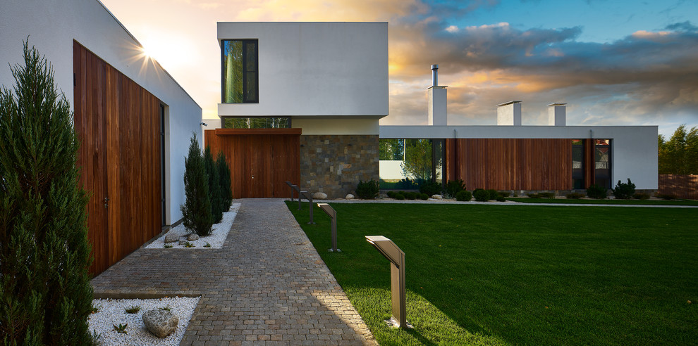 Immagine di un giardino design esposto a mezz'ombra di medie dimensioni e dietro casa in estate con pavimentazioni in pietra naturale e un ingresso o sentiero