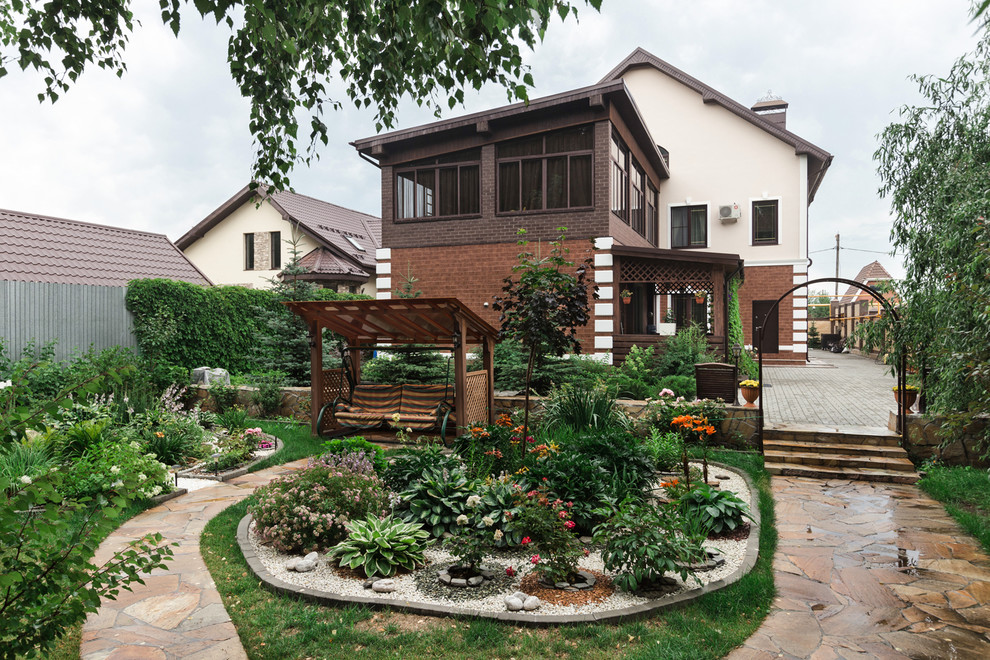 На фото: летний участок и сад на боковом дворе в современном стиле с клумбами
