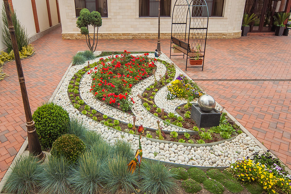 This is an example of a classic back formal full sun garden for summer in Other with brick paving and a flowerbed.