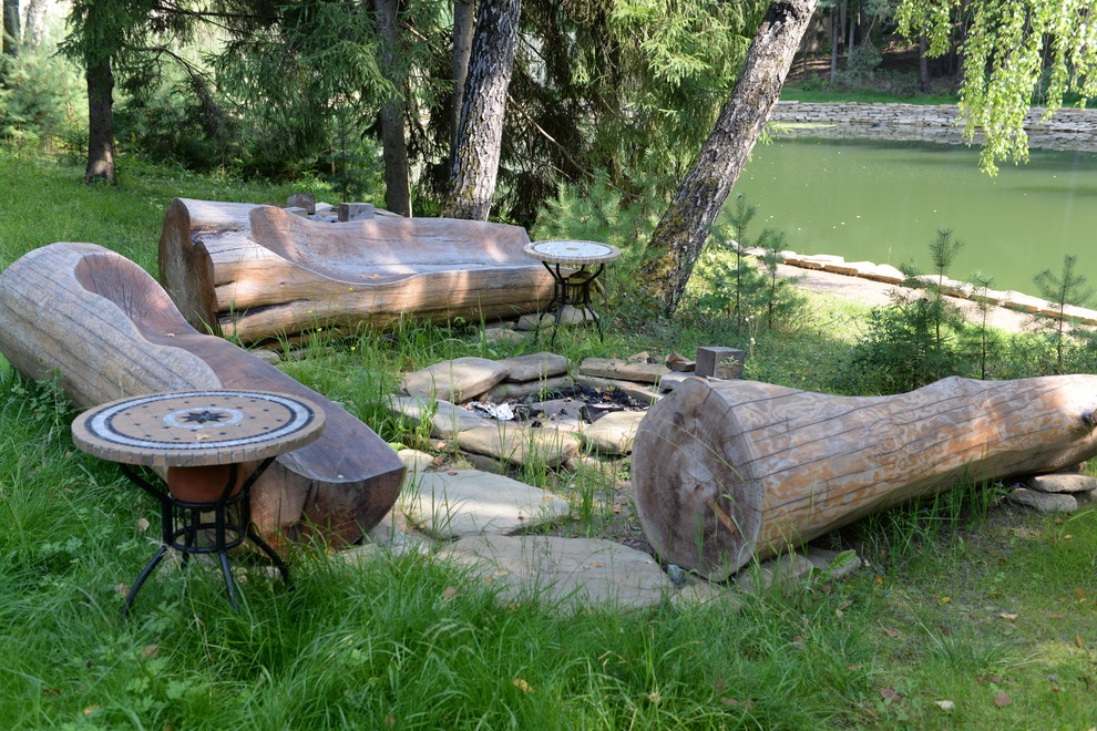 Foto på en rustik trädgård, med en damm och naturstensplattor