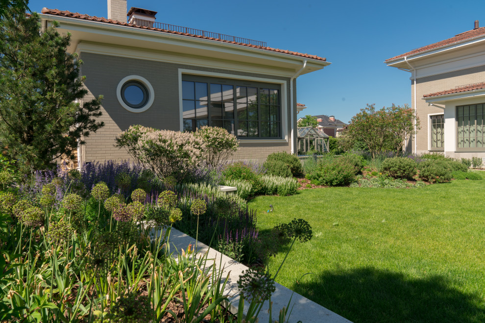 На фото: весенний участок и сад среднего размера на внутреннем дворе в стиле модернизм с подпорной стенкой