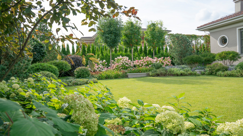 Esempio di un giardino xeriscape contemporaneo esposto in pieno sole di medie dimensioni e in cortile in estate con un muro di contenimento e pavimentazioni in cemento