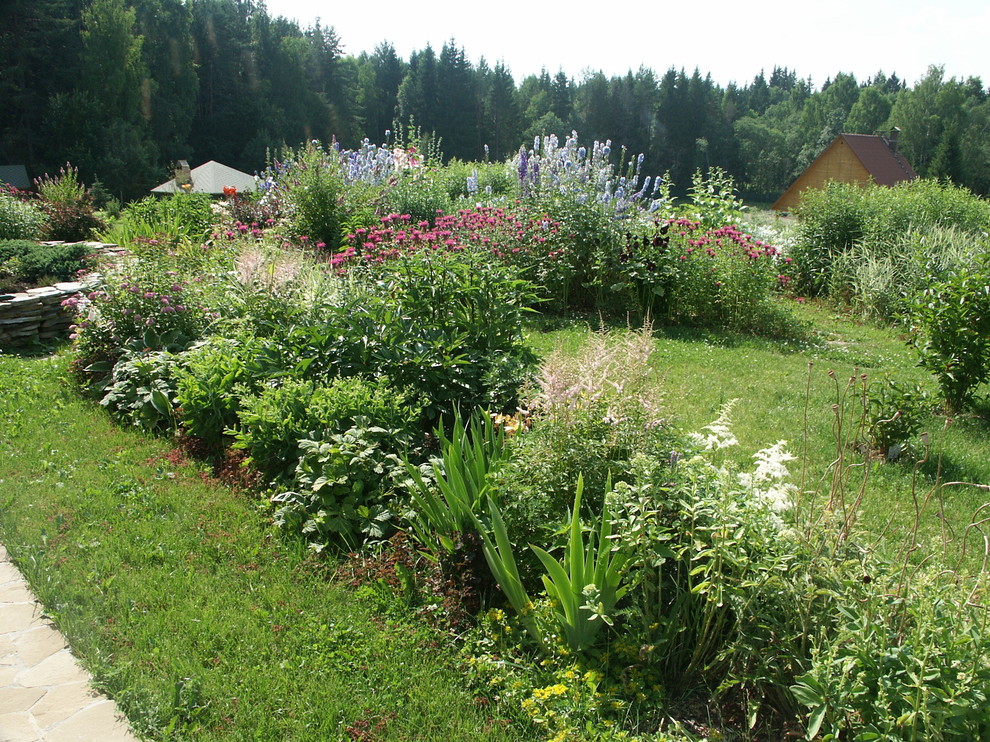 Design ideas for a large farmhouse full sun hillside landscaping in Moscow for summer.