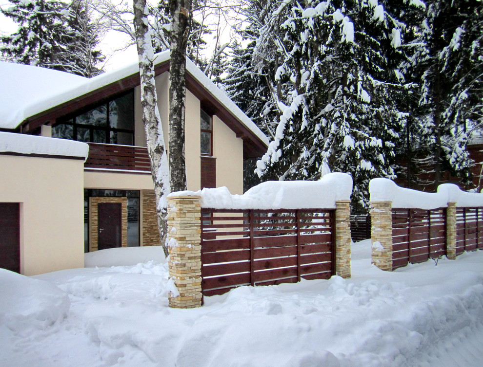 Imagen de acceso privado escandinavo de tamaño medio en invierno en patio delantero con portón, exposición total al sol, adoquines de piedra natural y con piedra