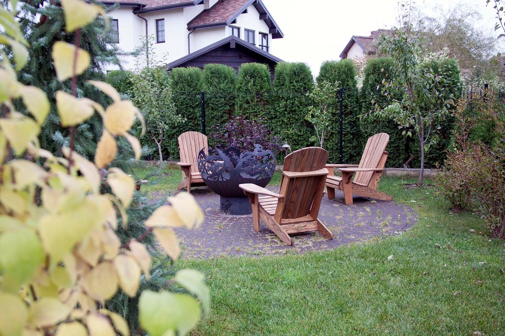 Photo of a medium sized bohemian full sun garden for autumn in Moscow with a fire feature and natural stone paving.