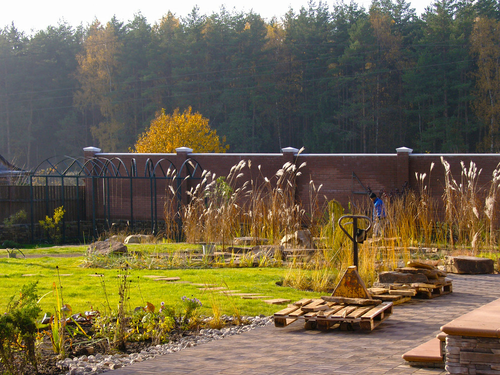 Diseño de jardín clásico de tamaño medio en otoño en patio con exposición parcial al sol y gravilla