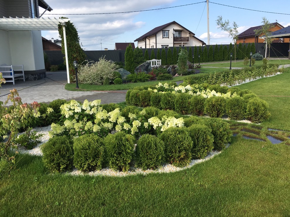 Idéer för en klassisk trädgård i full sol på sommaren, med en stödmur