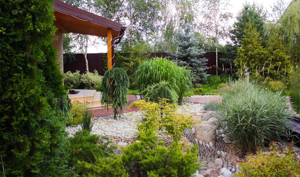 Diseño de jardín clásico de tamaño medio en verano con exposición parcial al sol, adoquines de ladrillo, jardín francés y roca decorativa