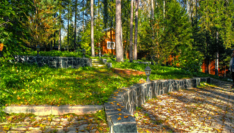 Foto di un vialetto d'ingresso bohémian esposto a mezz'ombra di medie dimensioni in autunno con un pendio, una collina o una riva, pavimentazioni in cemento e un muro di contenimento