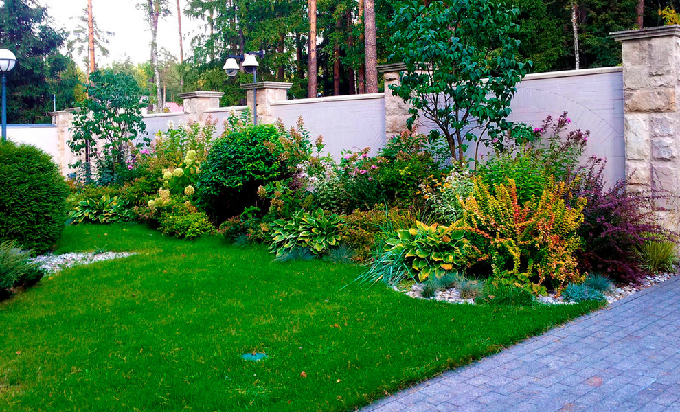 Idee per un ampio giardino vittoriano esposto in pieno sole davanti casa in autunno con pavimentazioni in pietra naturale